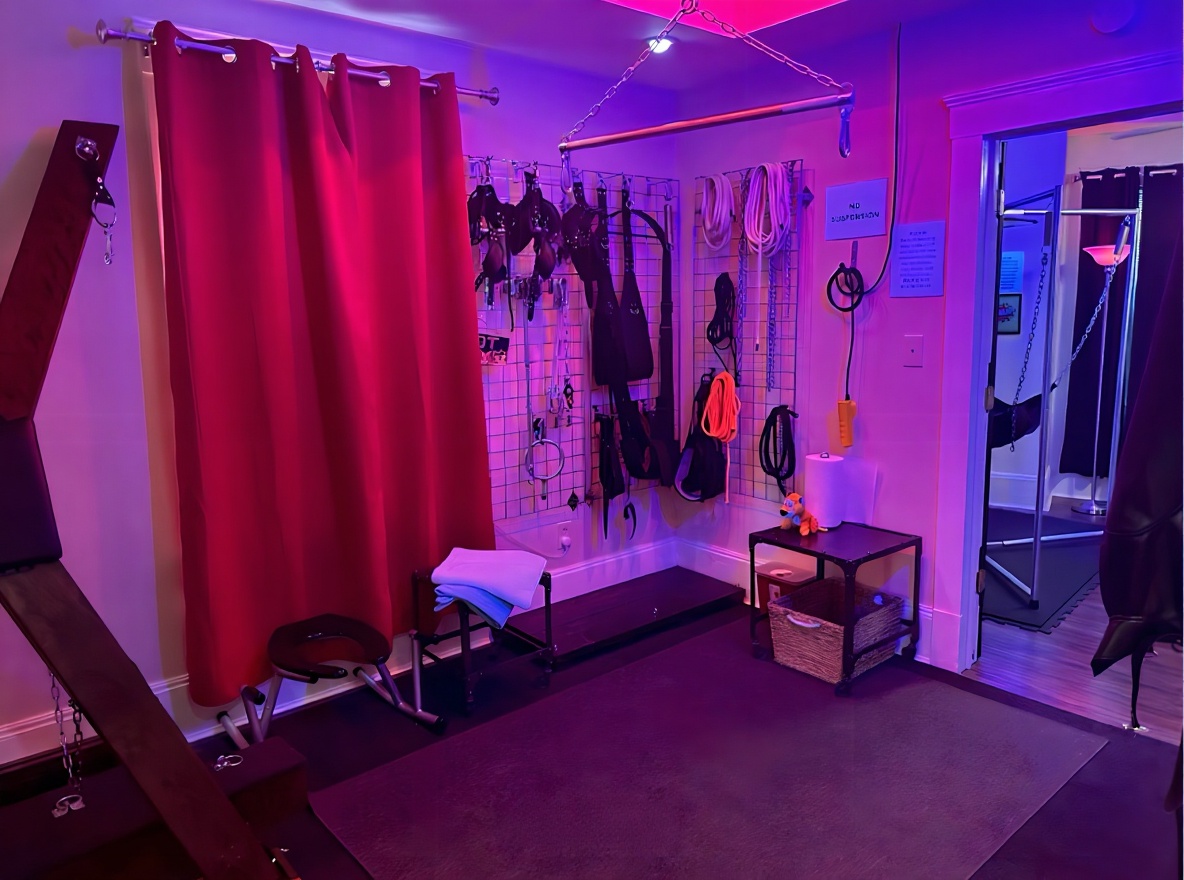 Play space with crimson curtain, rope wall, and bench