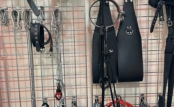 Wall of leather restraints, cuffs, and hardware